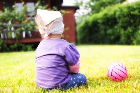 Cute baby on grass in garden の写真素材