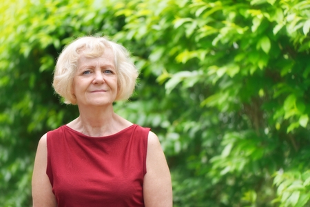 Mature, blonde woman in garden,の写真素材