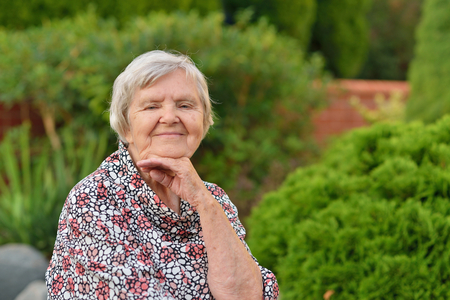Senior happy woman smiling in garden の写真素材