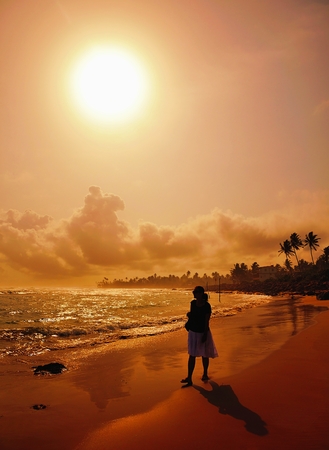 Woman on beach at sunset.の写真素材