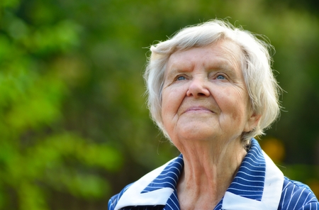 Senior happy woman smiling in garden.