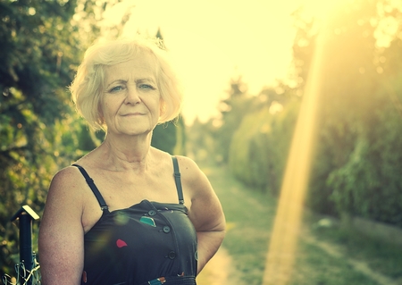 Mature, blonde woman in garden, Vintage Style.の写真素材