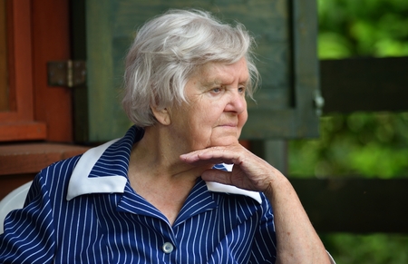 Senior happy woman smiling in garden.