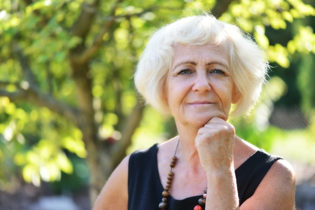 Mature, blonde woman in garden,の写真素材