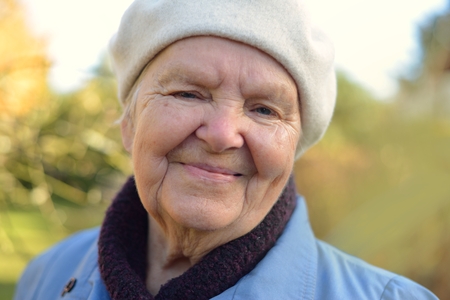 Senior happy woman smiling in garden.