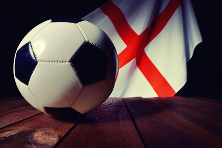 Flag of England with football on wooden boards as the background.の写真素材