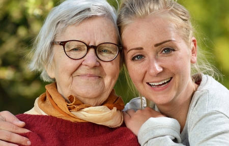 Grandmother and granddaughter. Young woman carefully takes care of an older woman.の写真素材