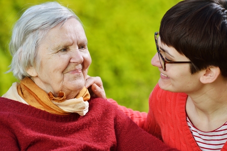 Grandmother and granddaughter. Young woman carefully takes care of an older woman.の写真素材