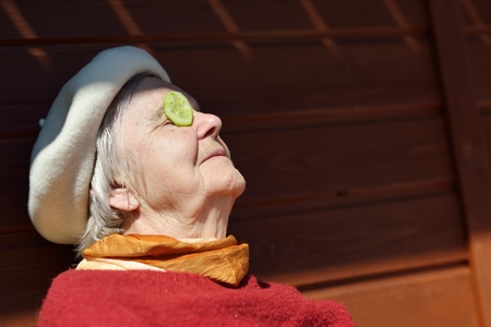 Elderly woman putting cucumbers on your eyes. For beauty and health.の写真素材