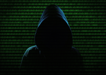 Hacker. Unrecognizable person in the hood break computer codes.