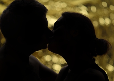 Man kissing woman on the golden circles background.の写真素材