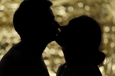 Man kissing woman on the golden circles background.の写真素材