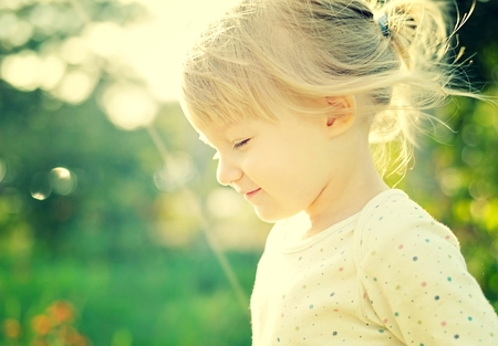 Cute little girl in the sunshine. Back lighting.の写真素材