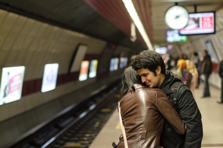 Istanbul, Turkey - February 25, 2013  Young couple embracing in Istanbul taksim square subway station while other passengers are waiting for the train のeditorial素材