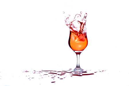 Cocktail splashes as ice is thrown inの写真素材