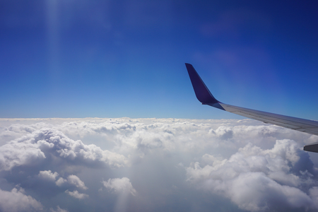 cloudy sky and airplane wing view from windowの写真素材