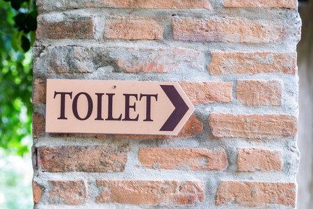 Guide post arrow to toilet on brick columnの写真素材
