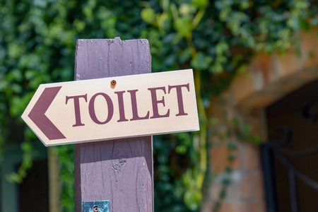 Guide post arrow to toilet on wood columnの写真素材