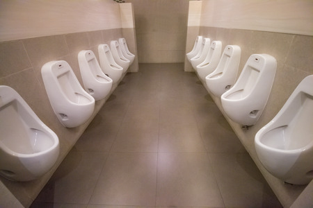 row white urinals in men's bathroom toiletの写真素材