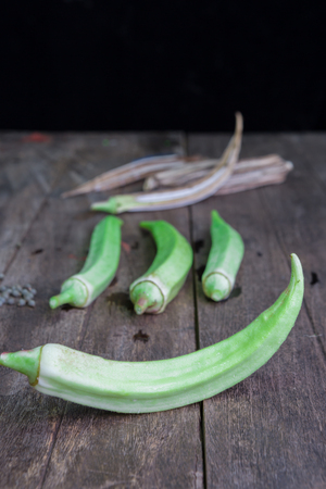 Lady Fingers or Okra over wooden backgroundの写真素材