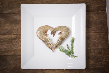 fresh shrimp isolated on  white plate on woodenの写真素材