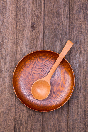 empty wood bowl and spoon on wooden backgroundの写真素材