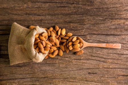 Almonds in sack on on wooden backgroundの写真素材