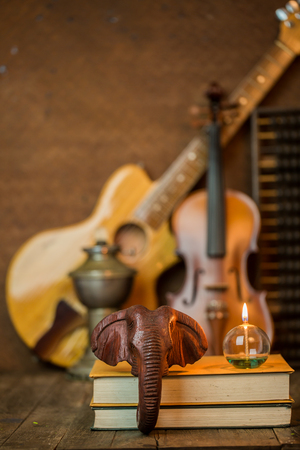 Acoustic guitar,violin,book and abacus lay on floor and steel background interior decoration still life styleの写真素材