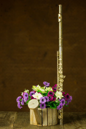 Silver flute and flower on old steel backgroundの写真素材
