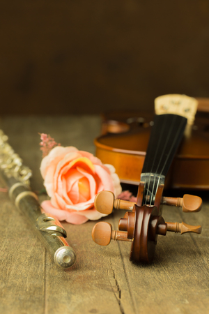 Silver flute and violin on wooden backgroundの写真素材