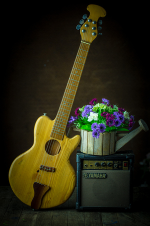 Acoustic guitar and amplifier resting against old steel background with copy spaceの写真素材