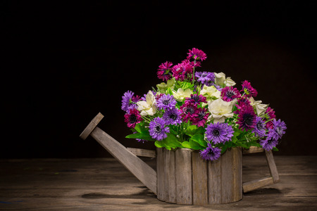 flowers in a woodden pot with black background,vintage styleの写真素材