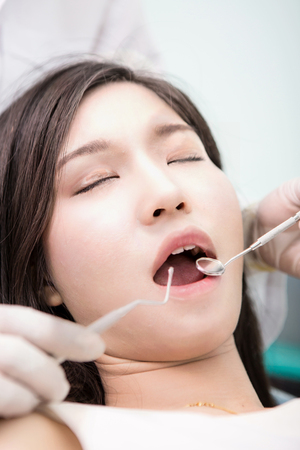 Dentist examining a patient's teeth in the dentist.の写真素材