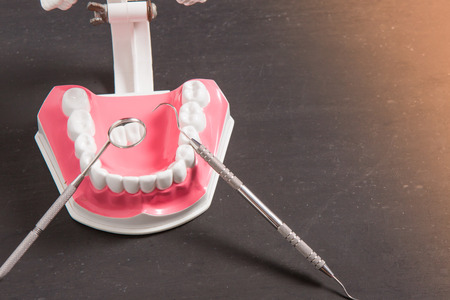 teeth model with dental equipment  on black background