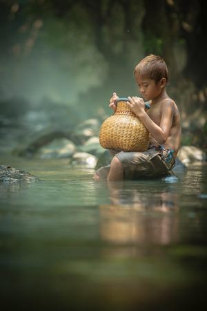 asian boy fishing in the riverの写真素材