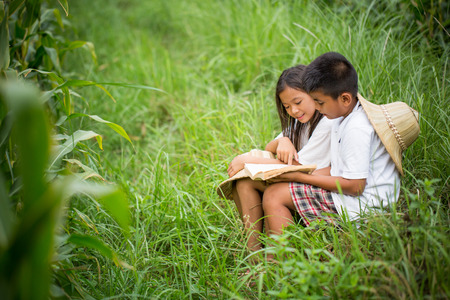 young asian reading a book in the parkの写真素材