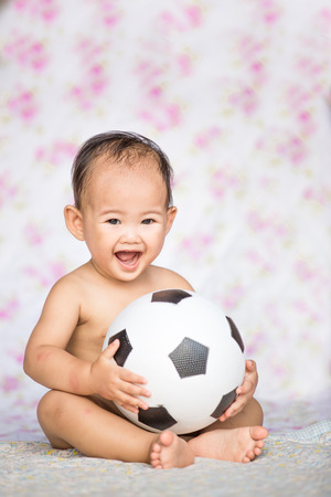 Asian baby boy playing soccer ballの写真素材