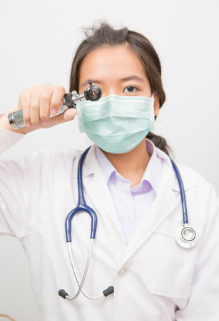 Doctor  looks through otoscope instrumentの写真素材