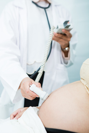 Doctor use digital medical tool check fetal heart sound to pregnancy womanの写真素材