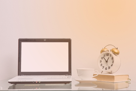 Table with laptop and cup of coffee on it, close upの写真素材