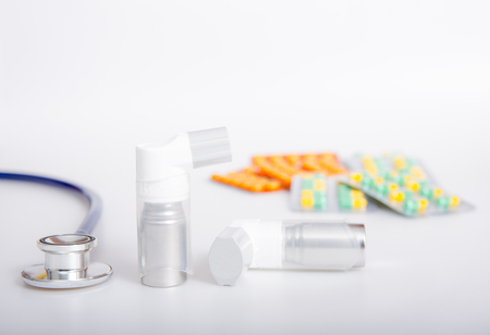 asthma inhaler and medicine on white background