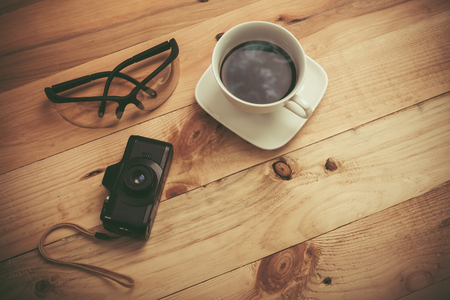 cup of coffee ,camera and eyeglass on woodenの写真素材