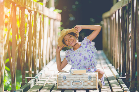 asian girl reading book on the old bridge in the forestの写真素材