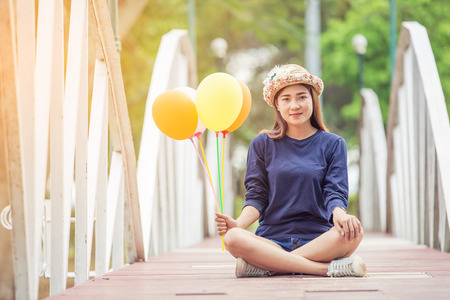 young woman holding  colorful balloons in the gardenの写真素材