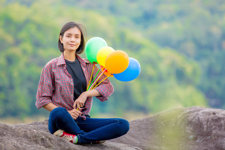 Happy young woman holding balloon in background natureの写真素材