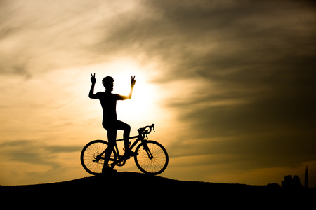man with bicycle on sunsetの写真素材