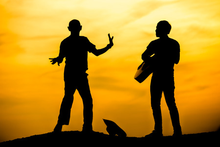 silhouette of musician with guitar at sunset