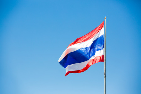 waving Thai flag of Thailand with blue sky background.の写真素材