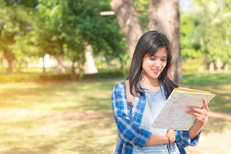 Woman reading a map in the forest