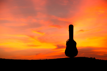 Silhouette of guitar case at sunsetの写真素材